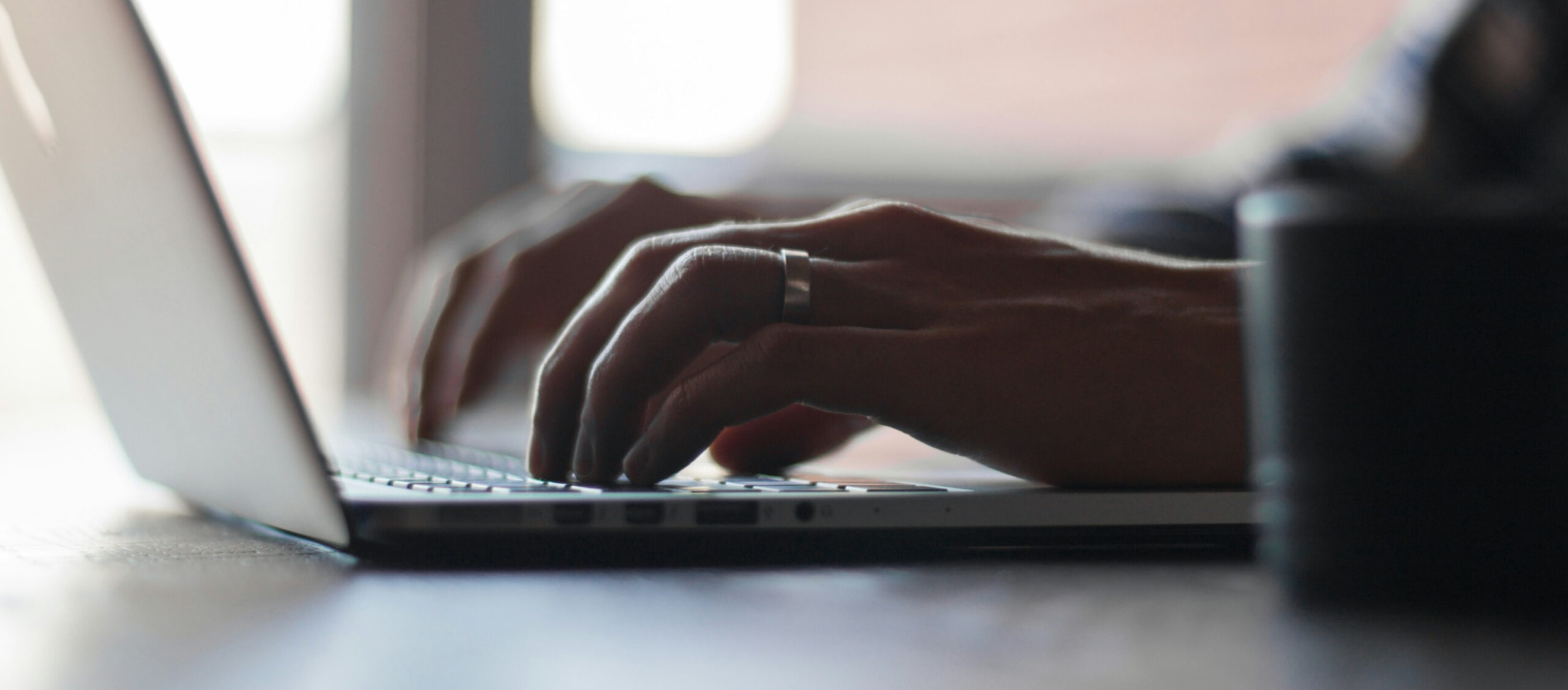 Hands typing on a laptop keyboard