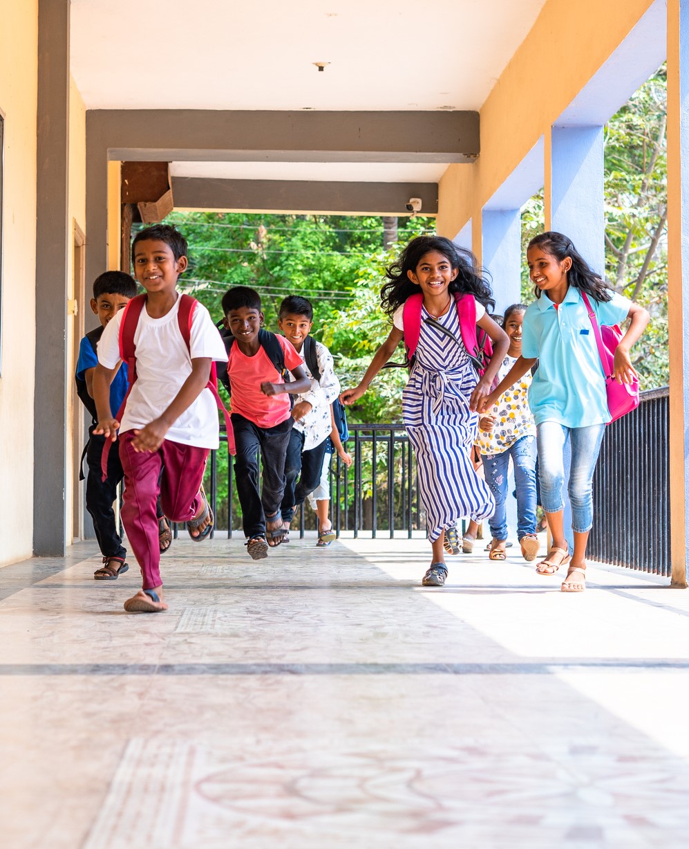 Children happily running in a corridor