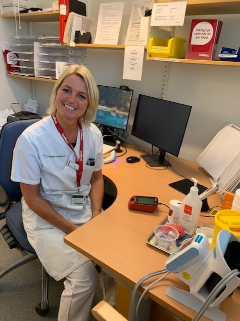 Nurse sitting by her desk smiling