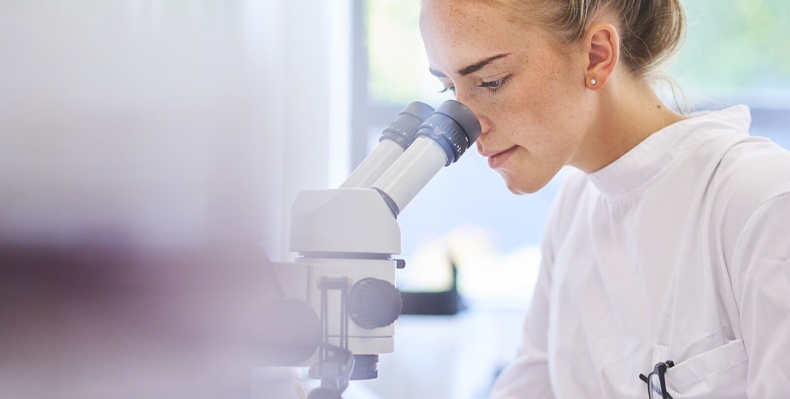 Female scientist looking into a microscope