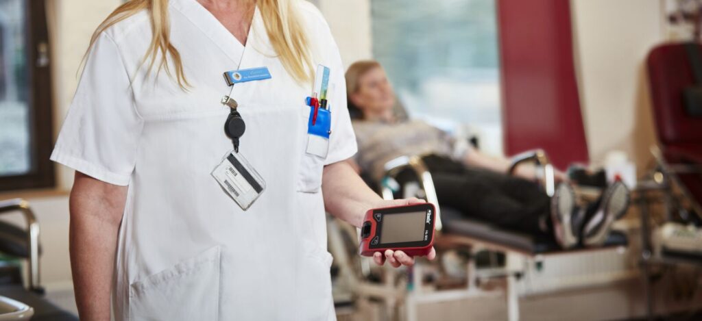 Female nurse holding a HemoCue Hb 801 Analyzer at a Blood Bank