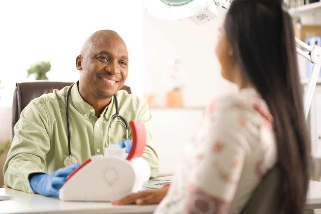 Male Doctor talking to female patient at Doctors Office