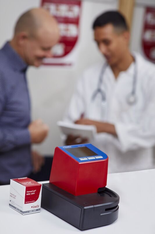 Doctor and patient in health care environment with WBC DIFF- white blood monitor system.